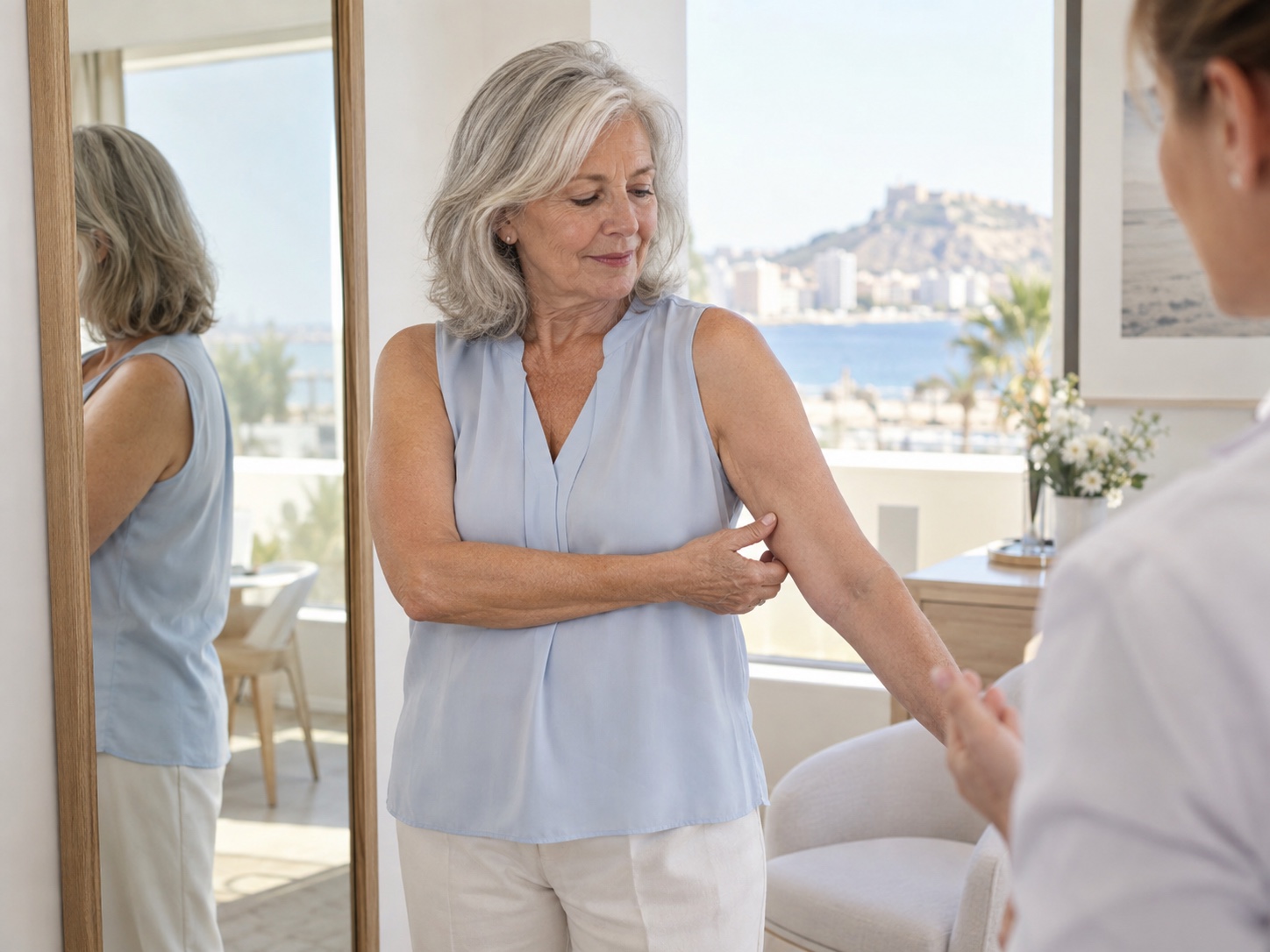 Mature woman discussing the contour of her upper arm during a consultation in Alicante
